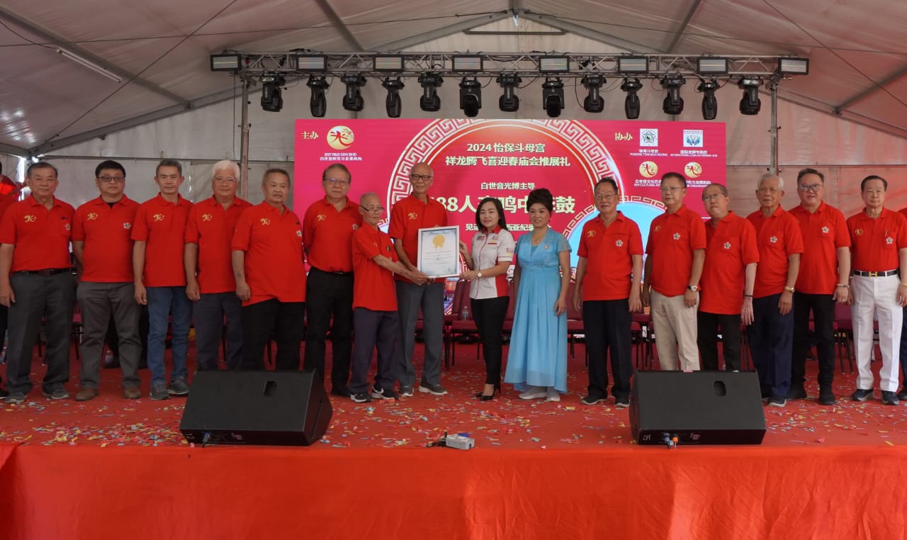 李佩玲（右8起）移交大马纪录大全证书予陈孟利和伍添福，并由郑国权（左起）、邱文传、黄健和、张文鼎、朱允楠、黄燕福、白世音光博、辛纶皓、李柏钊、陈永佳、余伟财、陈禗峻、叶细叻陪同见证。