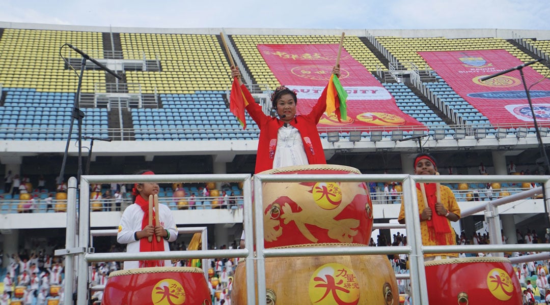 白世音在会场中央带领逾万鼓手，击鼓合奏。